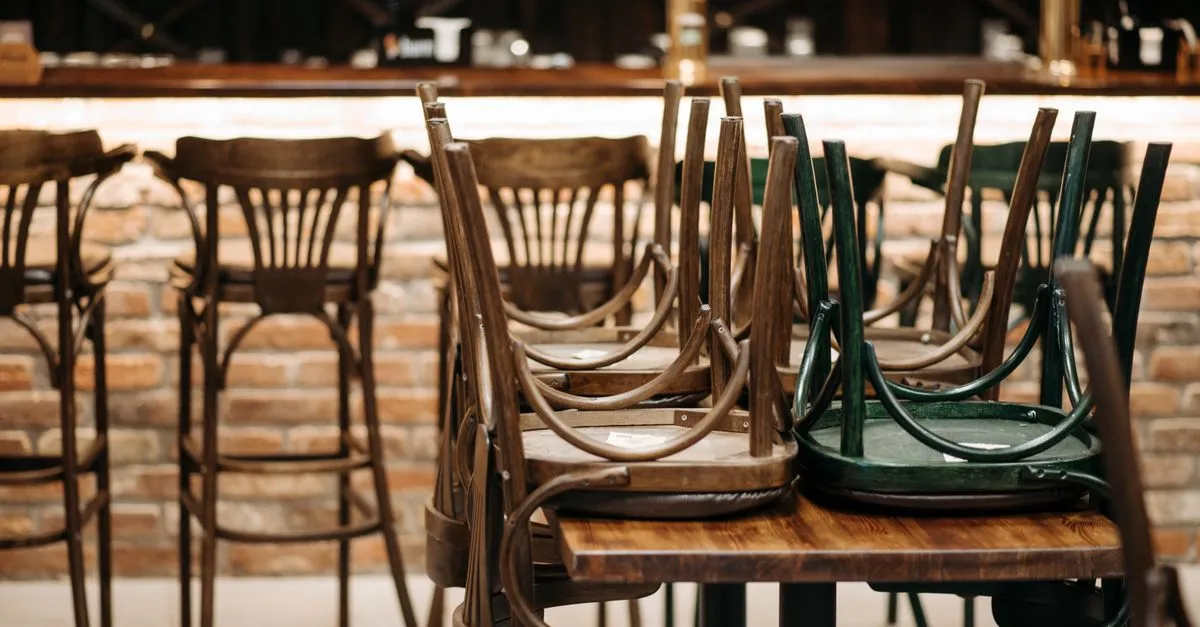 Lege stoelen in een gesloten restaurant, gordijnen dicht.