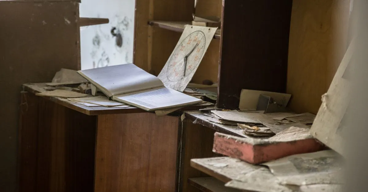 Een opengeslagen, vergeeld kasboek en een papieren klok tussen stoffige archiefkasten